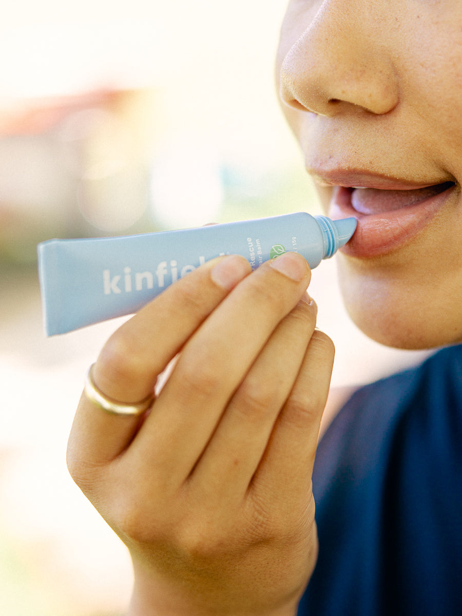 Woman applies Lip Rescue to her lips.
