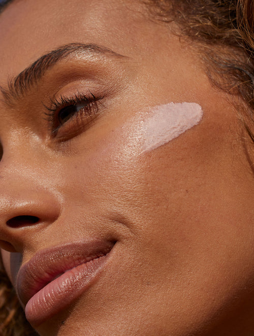Swatch of lightly rosy Sunglow SPF 35 swatched on a woman's cheek