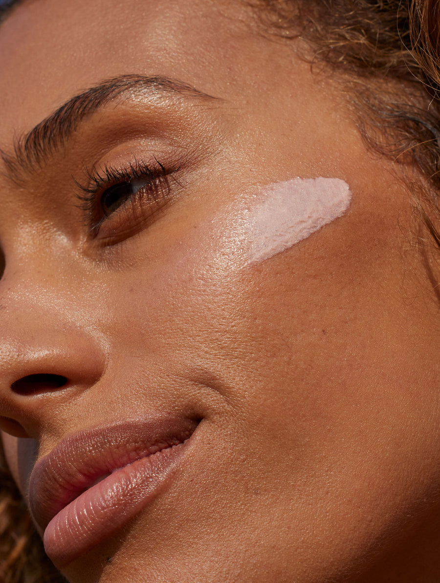 Swatch of lightly rosy Sunglow SPF 35 swatched on a woman's cheek